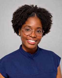 Brooke Moore Joseph in navy scrubs, smiling to camera